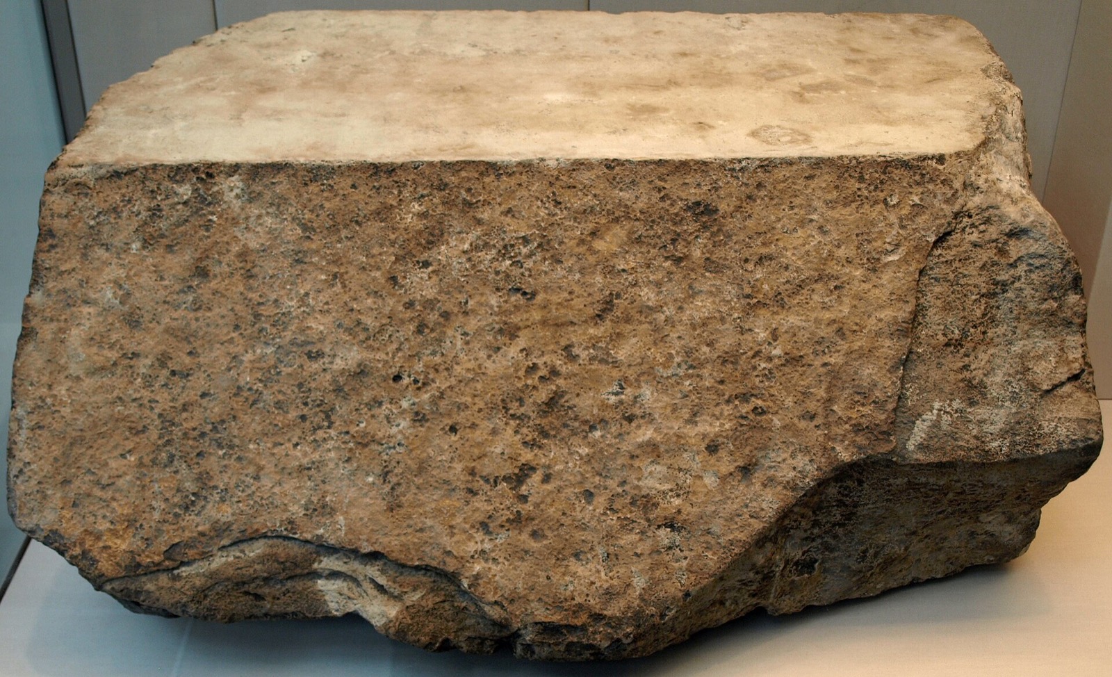A casing stone from the Great Pyramid of Khufu displayed in the British Museum, its outer face cut at a precise angle.