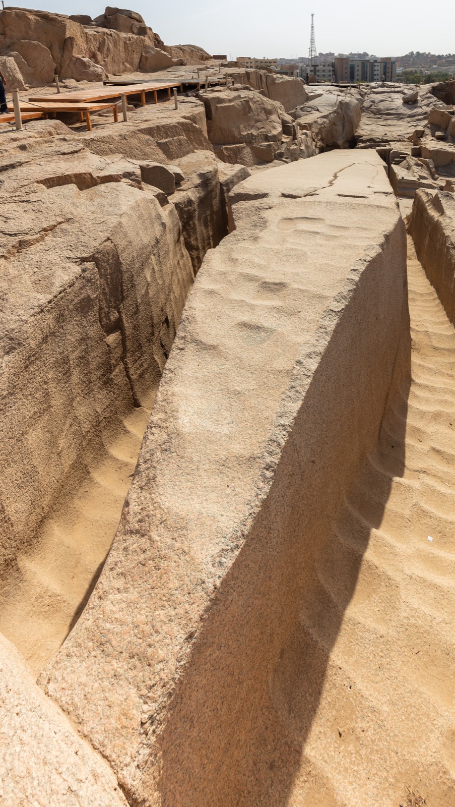 The Unfinished Obelisk at Aswan lying in its granite trench, the trench walls covered in rows of smooth scooped depressions.