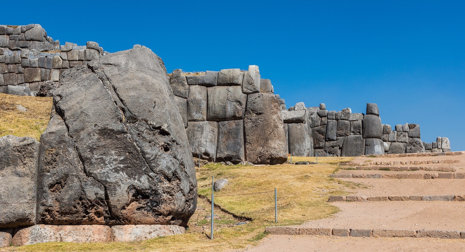 Close view of a Sacsayhuamán wall: massive polygonal stones with many-angled faces fitted tightly without mortar.